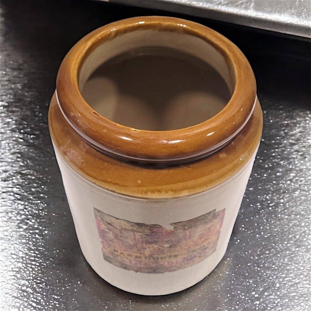 Orza de mermelada antigua de cerámica con etiqueta vintage de fresa, ideal para decoración rústica en cocinas o estanterías de estilo retro.