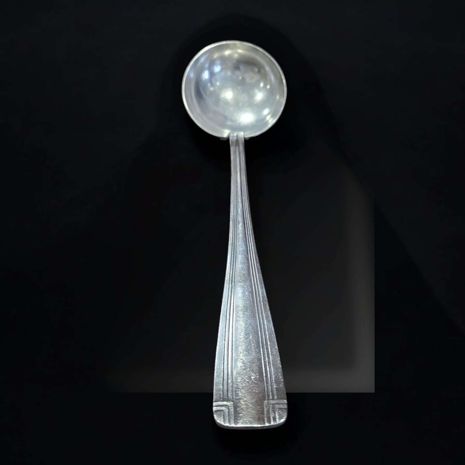 Cucharón antiguo de metal plateado elegante y funcional con mango decorado y diseño clásico, ideal para decoración vintage en cocina o comedor.