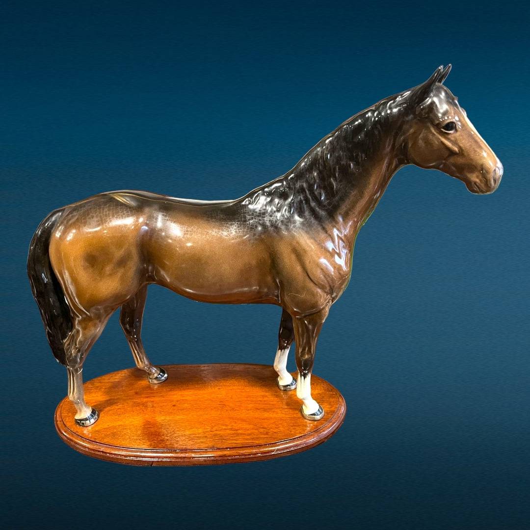 Figura de caballo en porcelana esmaltada Beswick sobre base de madera, perfecta para añadir un toque de elegancia clásica a interiores sofisticados.