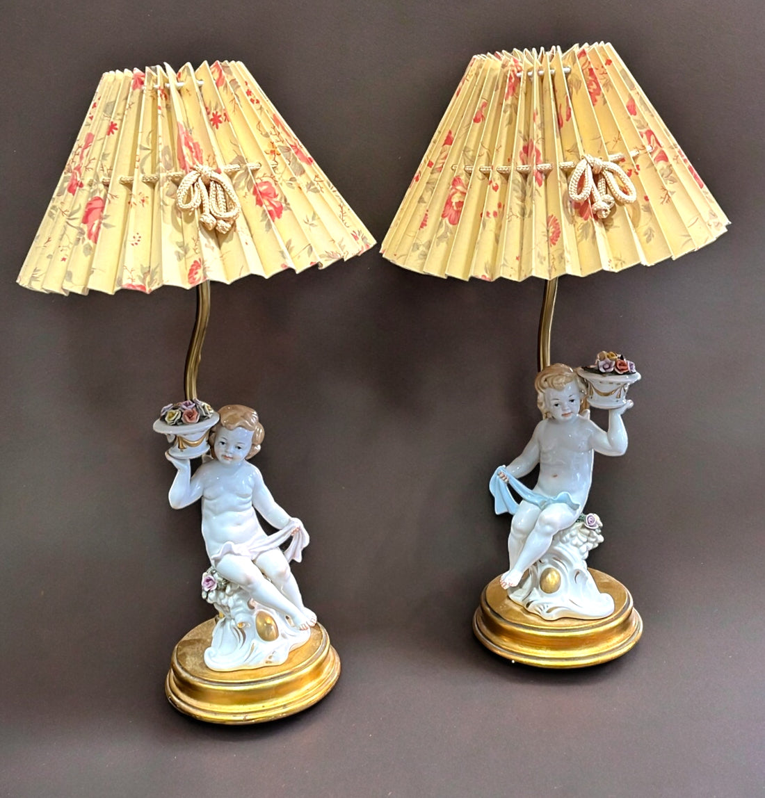 Pareja de lámparas de noche con querubines de porcelana y pantallas plisadas con diseño floral, ideales para decoración vintage.