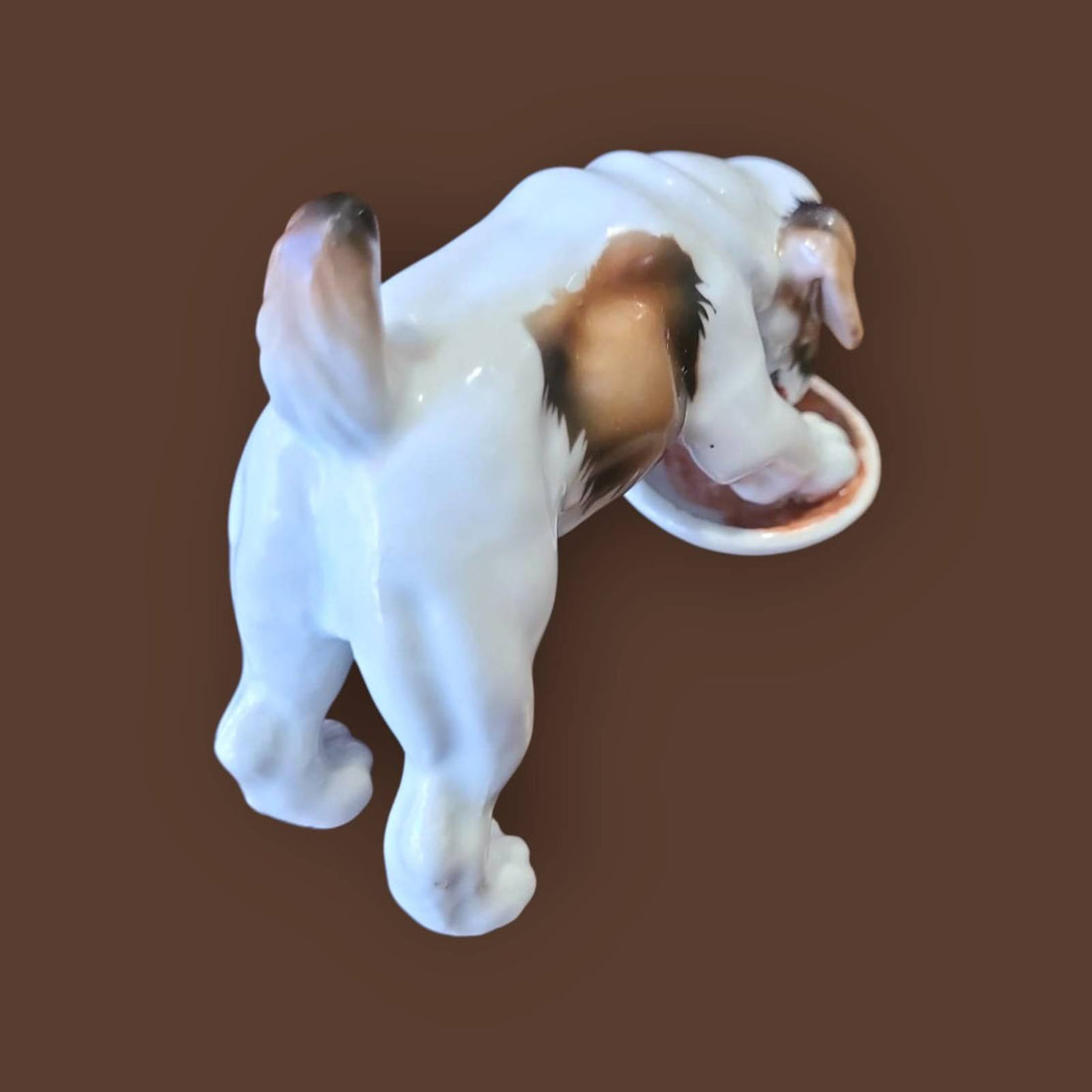 Figura de porcelana alemana de un cachorro beagle comiendo, diseño realista de Limbach años 50, ideal para colección de decoración vintage.