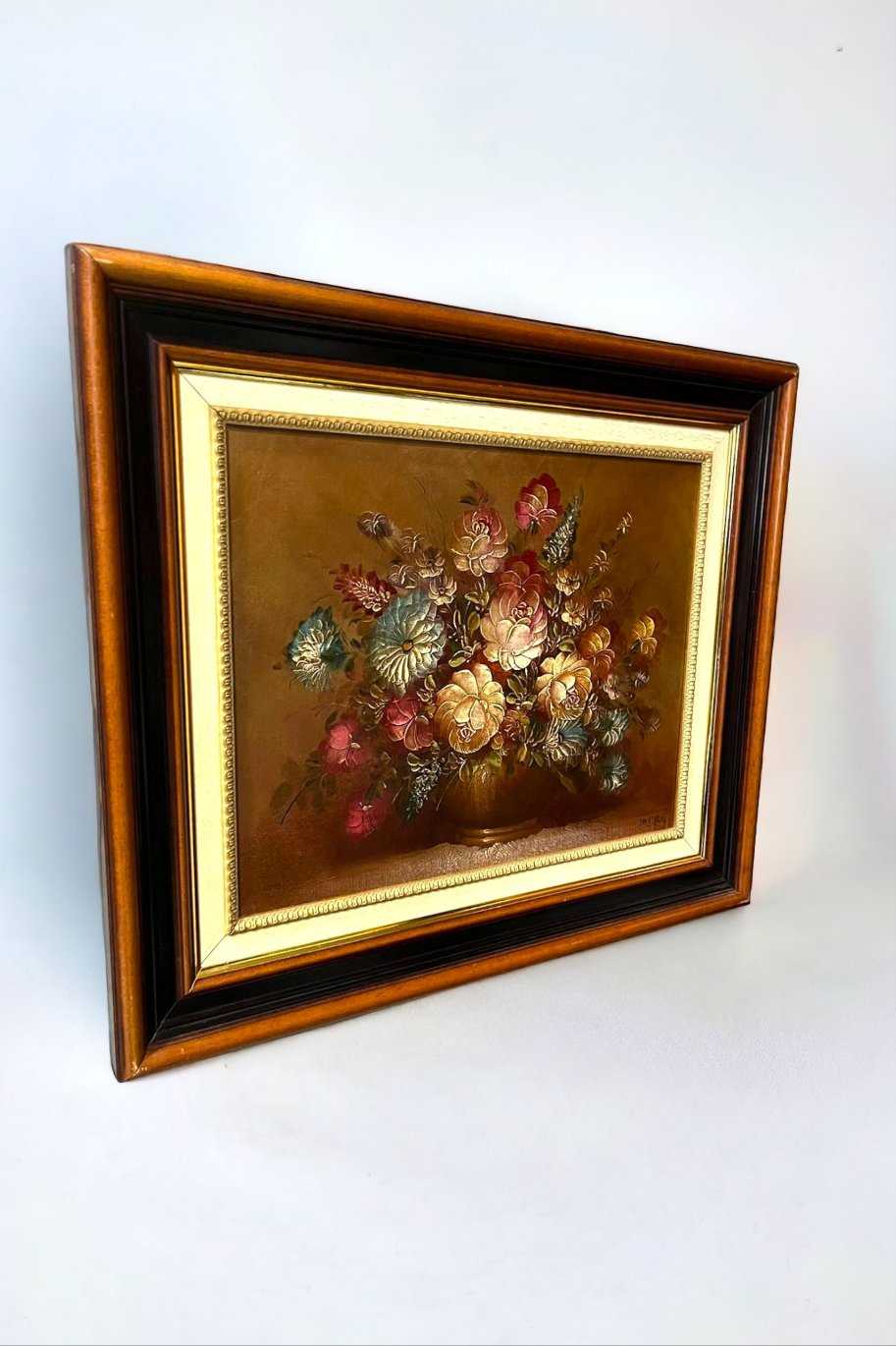 Óleo Floral de Juan Lara con centro floral vibrante en tonos cálidos, enmarcado en elegante marco de tres colores. Arte exclusivo para decoración sofisticada.