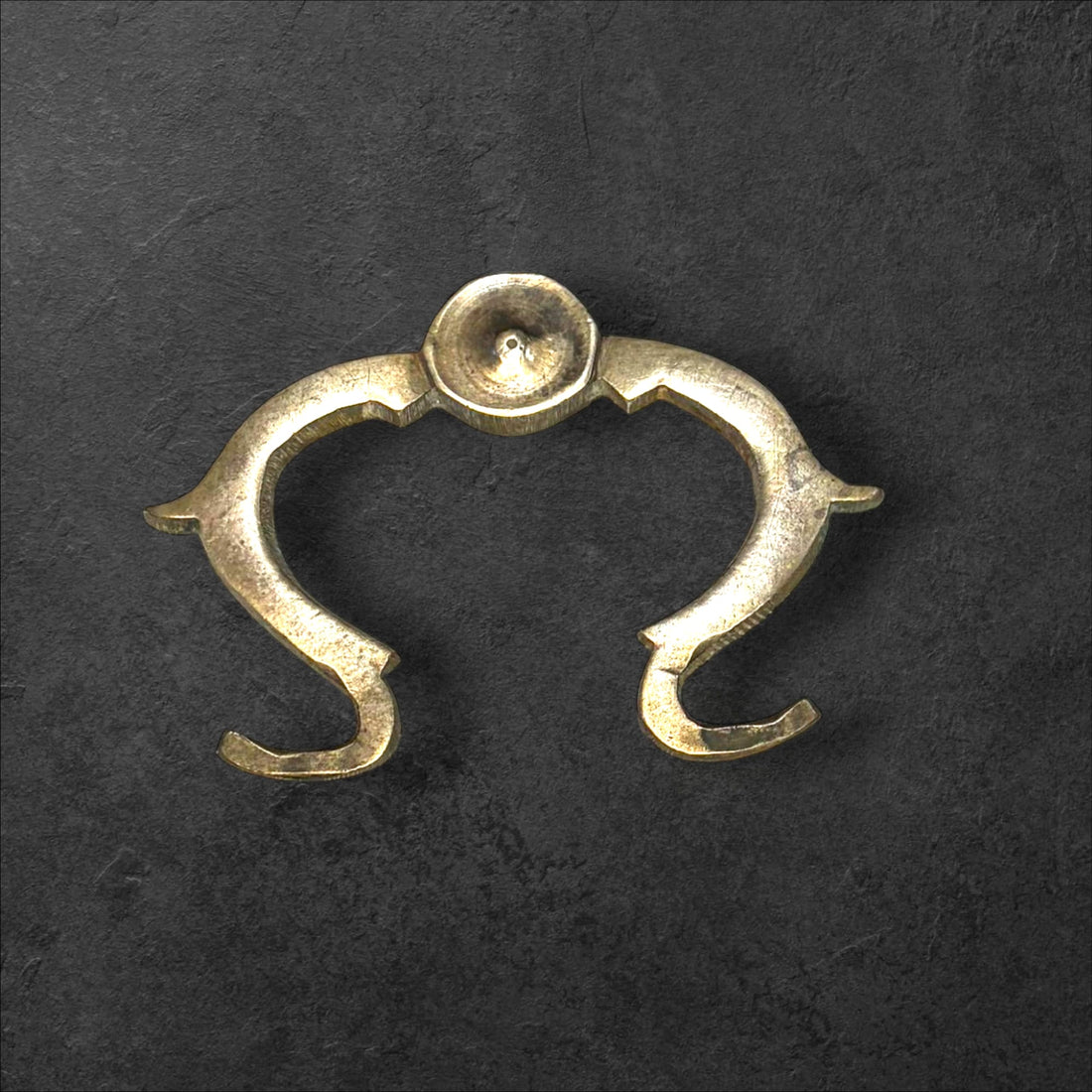 Tirador de metal antiguo original para muebles único con diseño curvo y acabado envejecido. Ideal para decoración vintage en restauración de muebles.