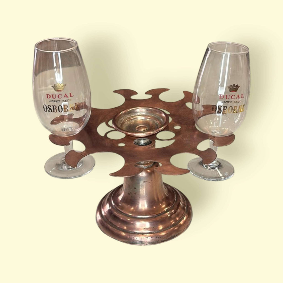 Soporte para copas de cobre antiguo único y decorativo con dos copas de cristal, ideal para decoración vintage en el hogar o bar.