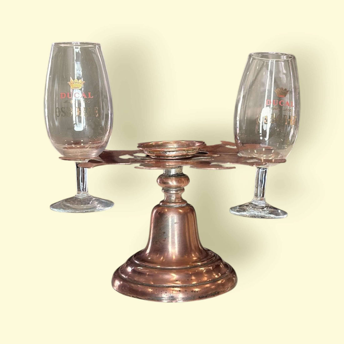 Soporte para copas de cobre antiguo único y decorativo con dos copas de cristal, ideal para decoración vintage en el hogar o bar.