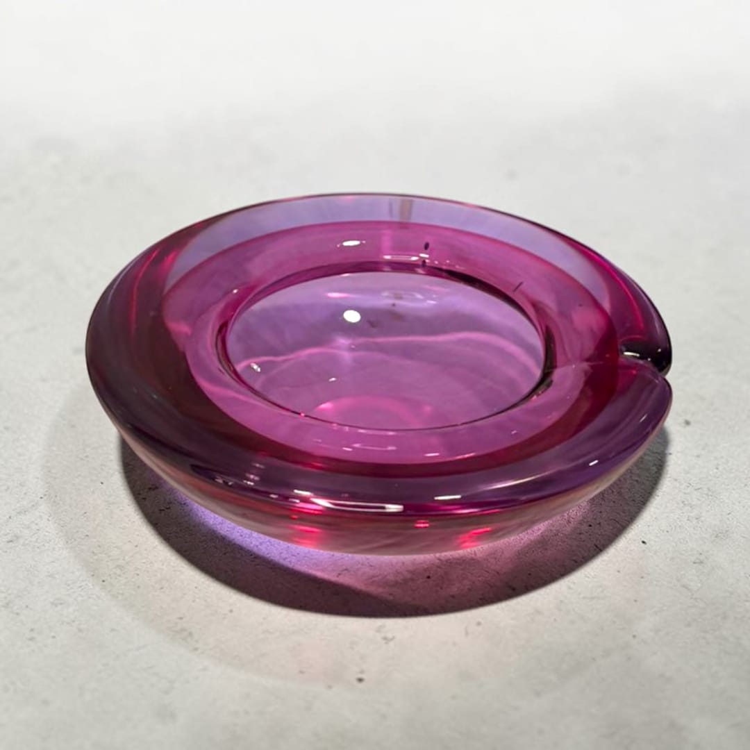 El Cenicero de cristal Murano violeta es una pieza decorativa que combina la funcionalidad cotidiana con la belleza del cristal artístico.