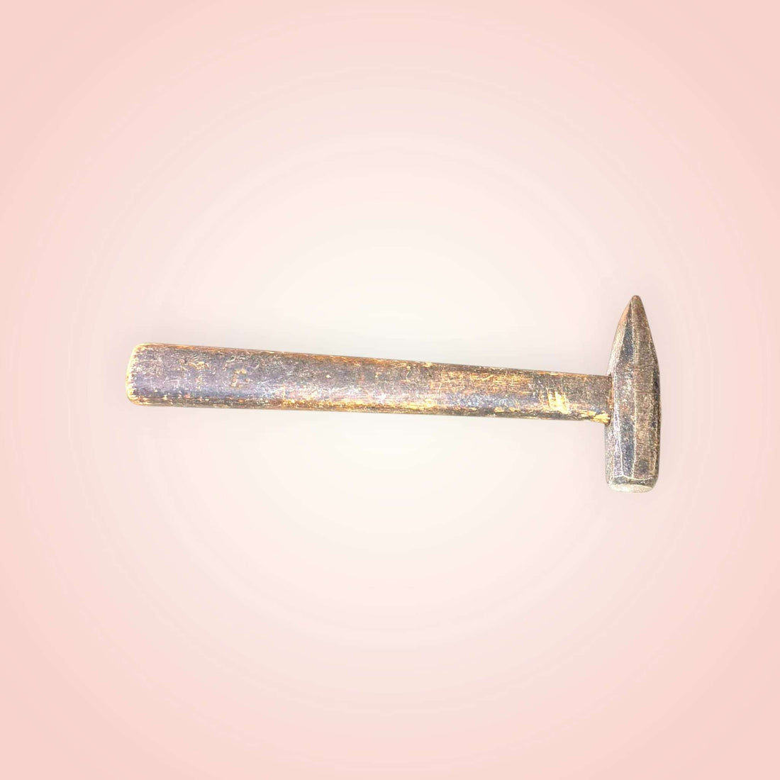 Se aprecia un cabezal de metal de líneas rectas, con una zona de golpeo compacta y una parte opuesta afilada, característica de herramientas tradicionales de oficio. 
