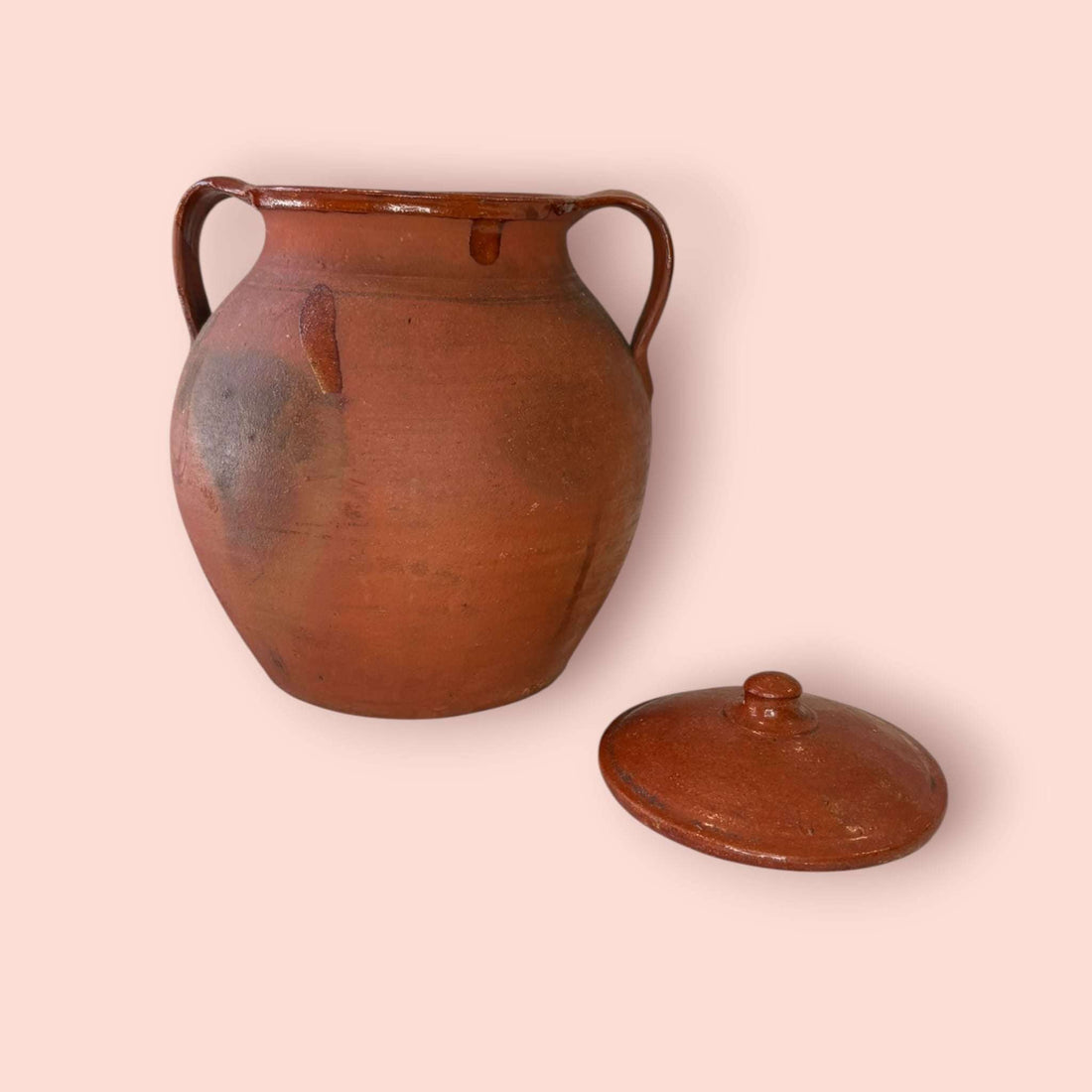 Esta Orza antigua de barro cocido es una pieza de fuerte carácter tradicional, pensada originalmente para conservar alimentos y mantener su contenido protegido gracias a su tapa y a la naturaleza del barro.