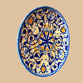 En las fotos se aprecia una composición muy cuidada, con motivo floral central, una red de roleos vegetales en azul cobalto, pequeños detalles estrellados y puntos en ocre cálido, todo ello sobre fondo claro.