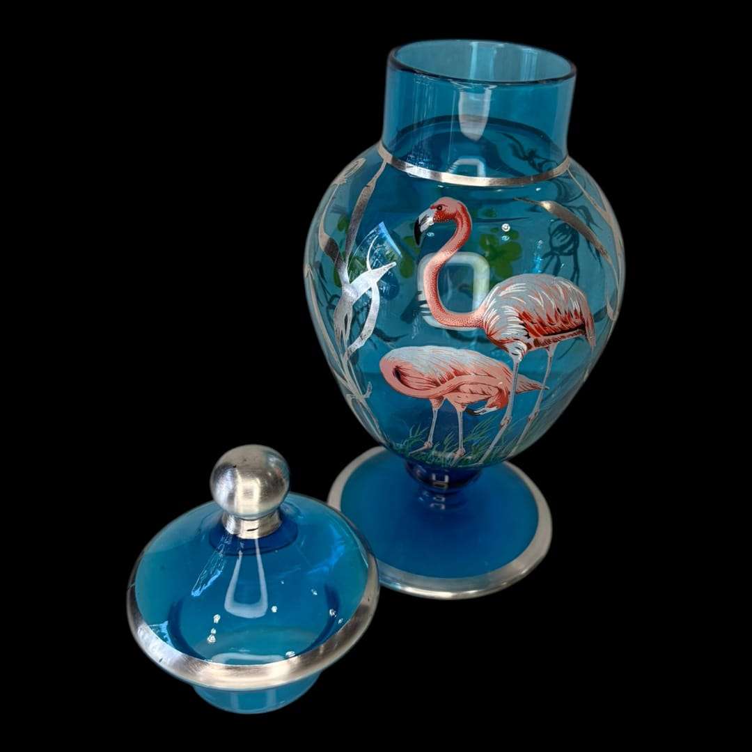 Este elegante Tibor de cristal azul es una pieza decorativa que destaca por su belleza exótica y su delicado trabajo artesanal. 