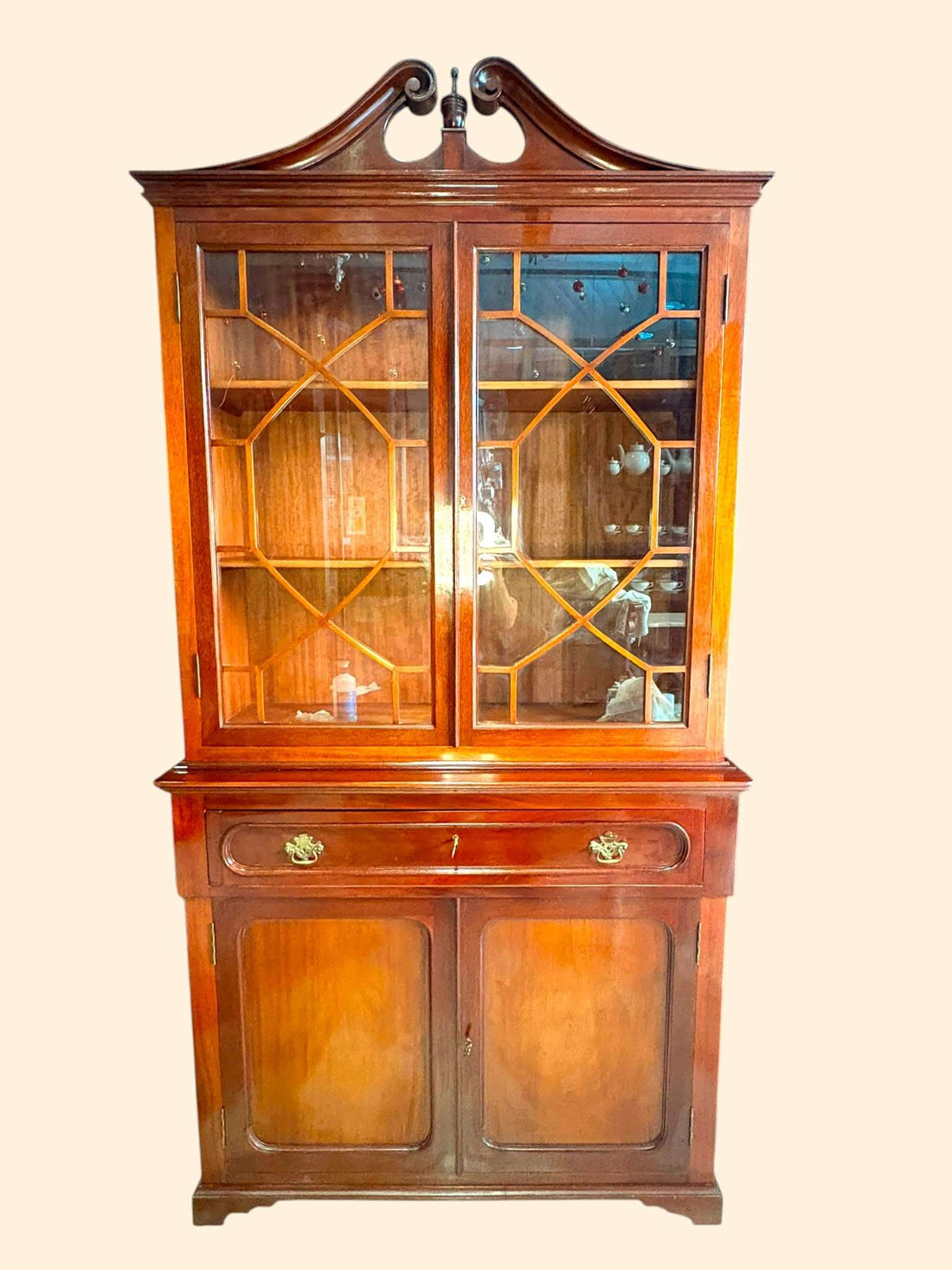 Esta Libería de caoba es una pieza antigua de gran presencia, diseñada para unir almacenaje, exposición y zona de trabajo en un solo mueble. 