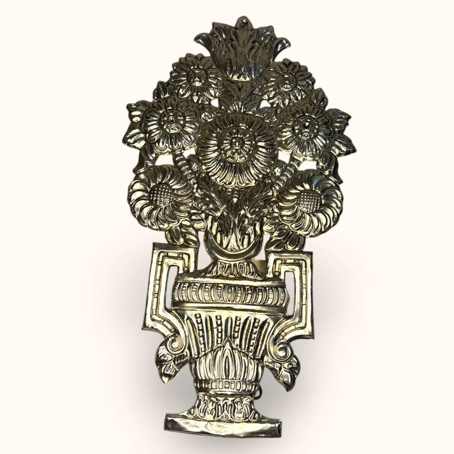 Su diseño floral recuerda a los ramos decorativos tradicionales, con una composición simétrica, volumen y un acabado metálico que encaja muy bien en interiores clásicos, vintage, eclécticos o románticos.