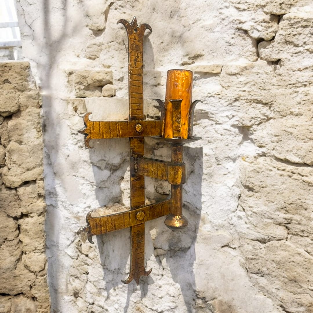 Aplique de pared de hierro estilo medieval con diseño rústico en forma de cruz, ideal para decoración histórica en interiores y exteriores.