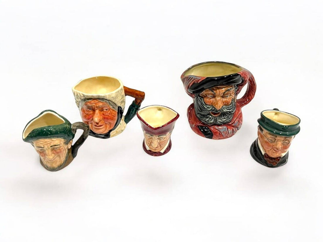 Jarras de porcelana Royal Doulton con rostros de personajes famosos como Falstaff y Mr. Pickwick, ideales para decoración vintage de interiores.