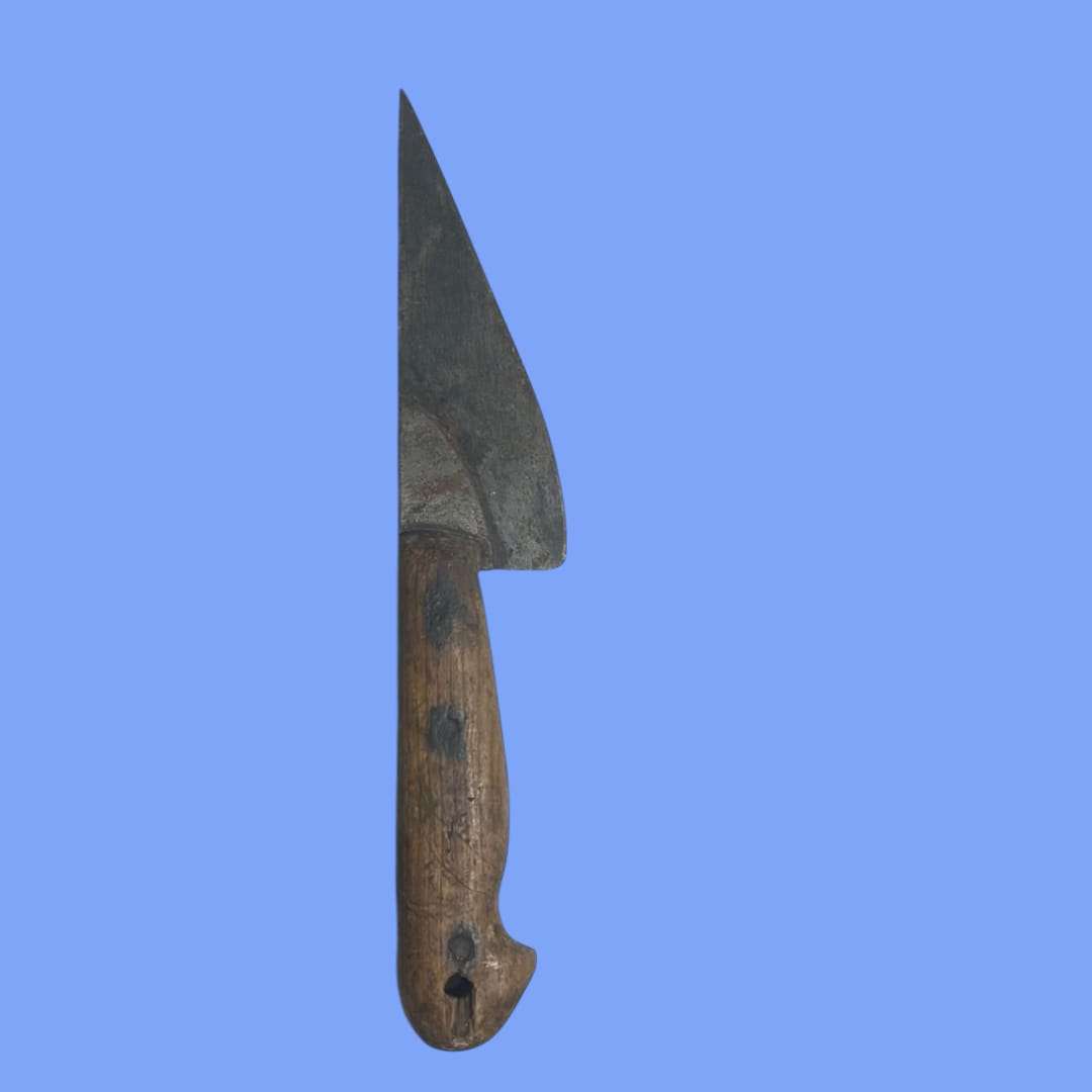 Cuchillo de carnicero antiguo visto en detalle, hoja de acero y mango de madera.