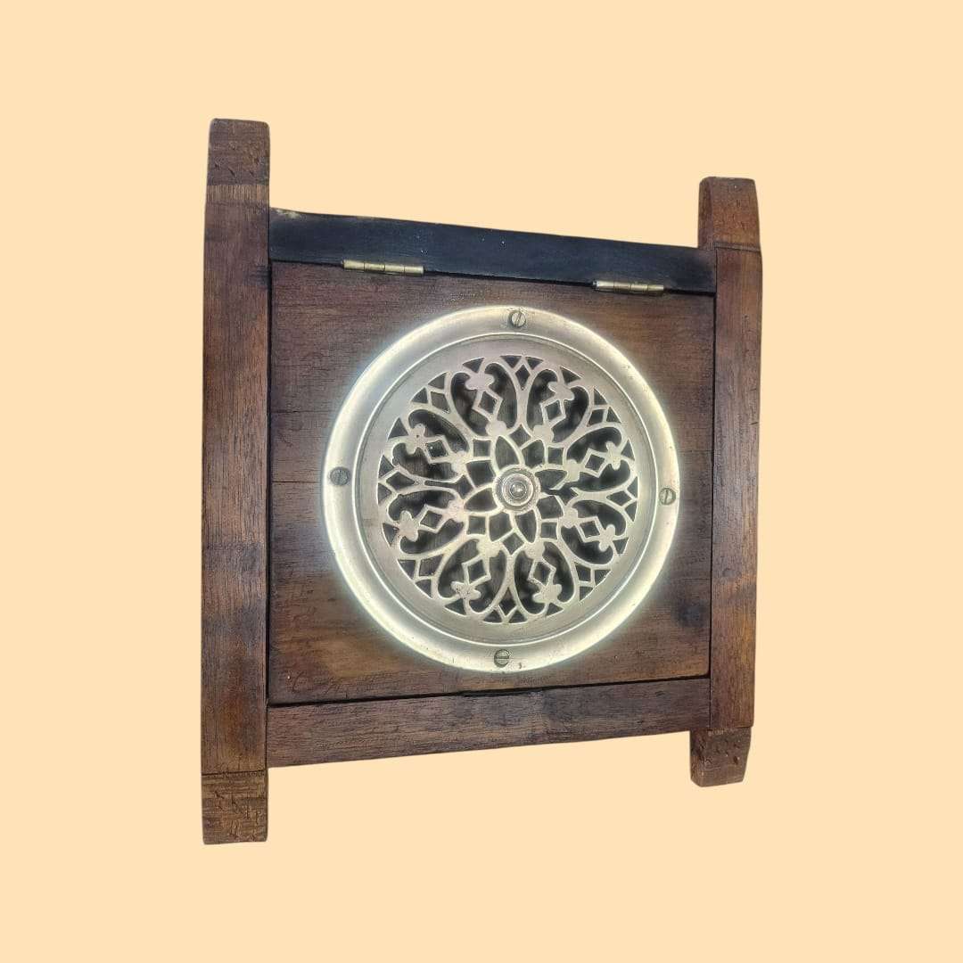 Mirilla antigua de madera maciza con círculo metálico dorado calado, ideal para decoración de puertas clásicas. Autenticidad y carácter únicos.