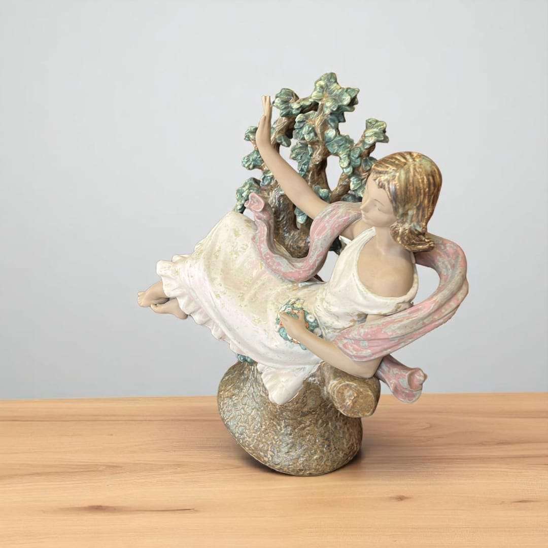 Escultura de porcelana Lladró Day Dream, mujer sentada junto a árbol en flor.