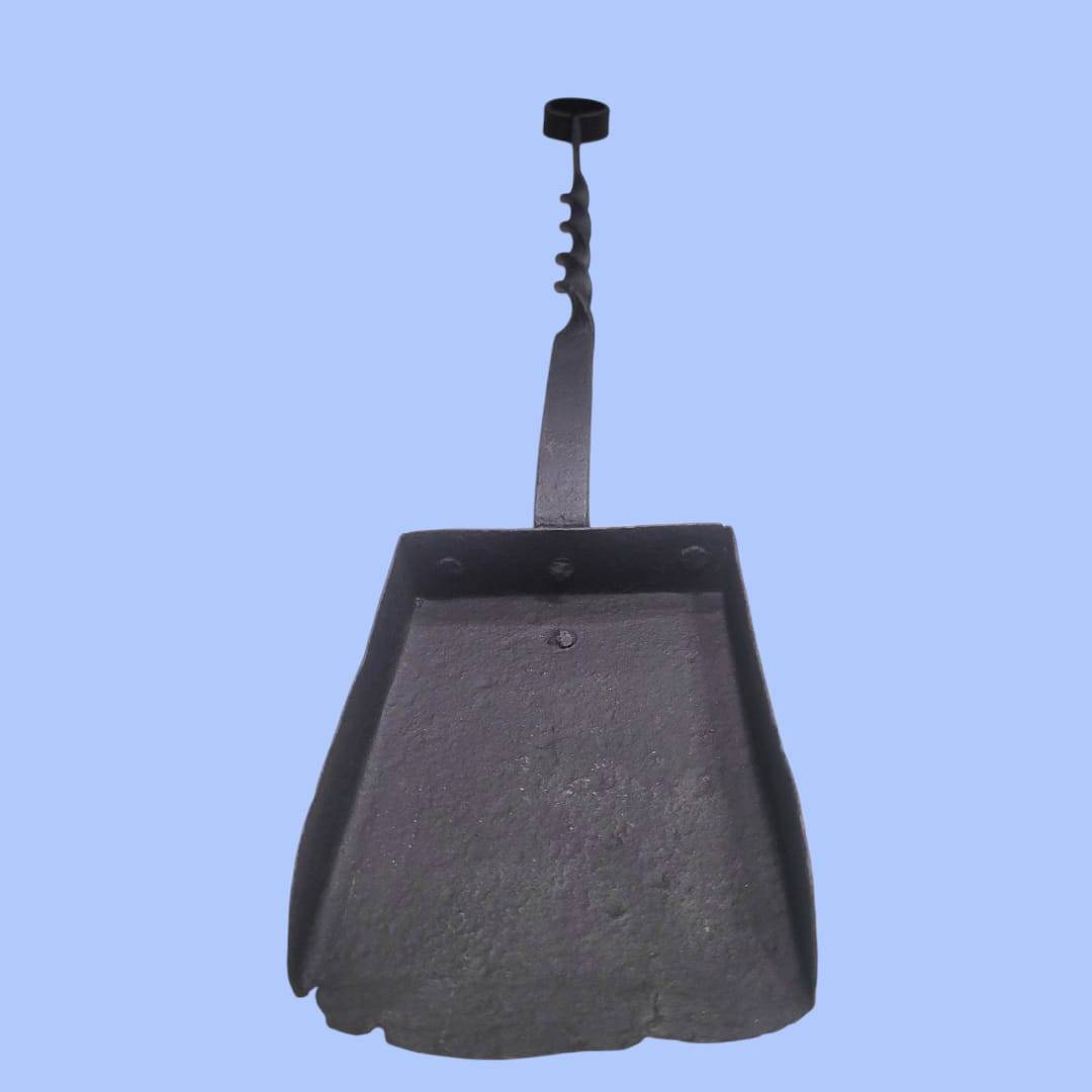 Pala de chimenea de forja artesanal con acabado rústico, vista frontal que resalta su diseño robusto y decorativo para uso en chimeneas.