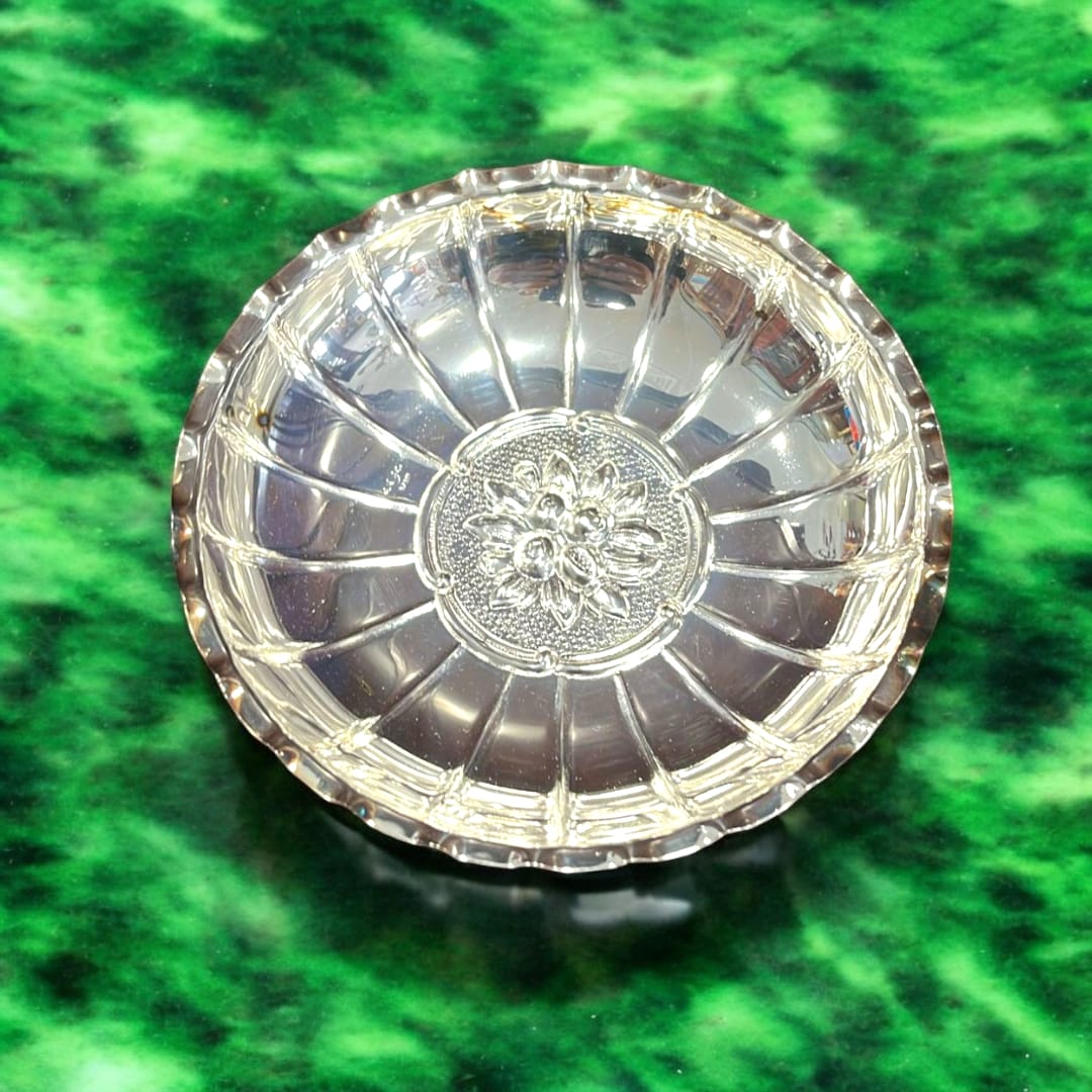 Panera de metal plateado con relieve floral, diseño elegante y duradero ideal para decoración de mesa en hogar o jardín.