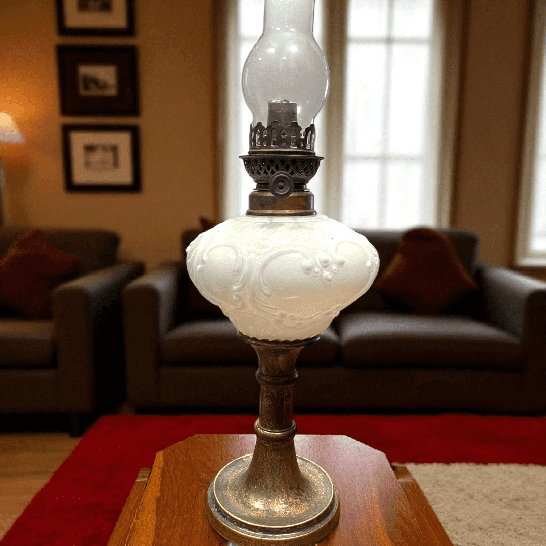 Quinqué vintage con opalina blanca y tulipa de cristal sobre mesa auxiliar en sala acogedora. Decoración clásica para hogar con estilo retro.
