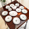 Vajilla Pontesa completa para 12 comensales, presentada sobre mesa de madera. Diseño floral sofisticado, perfecta para cenas elegantes.
