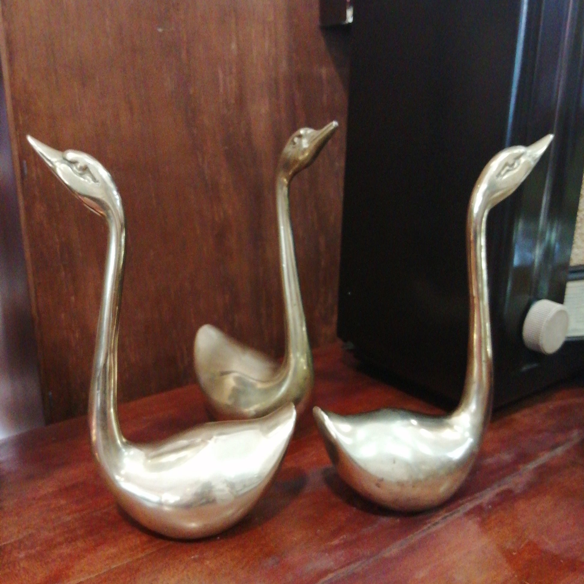 Conjunto de tres cisnes decorativos de metal antiguo con acabado brillante, perfectos para embellecer espacios interiores. Envío gratis en la península.