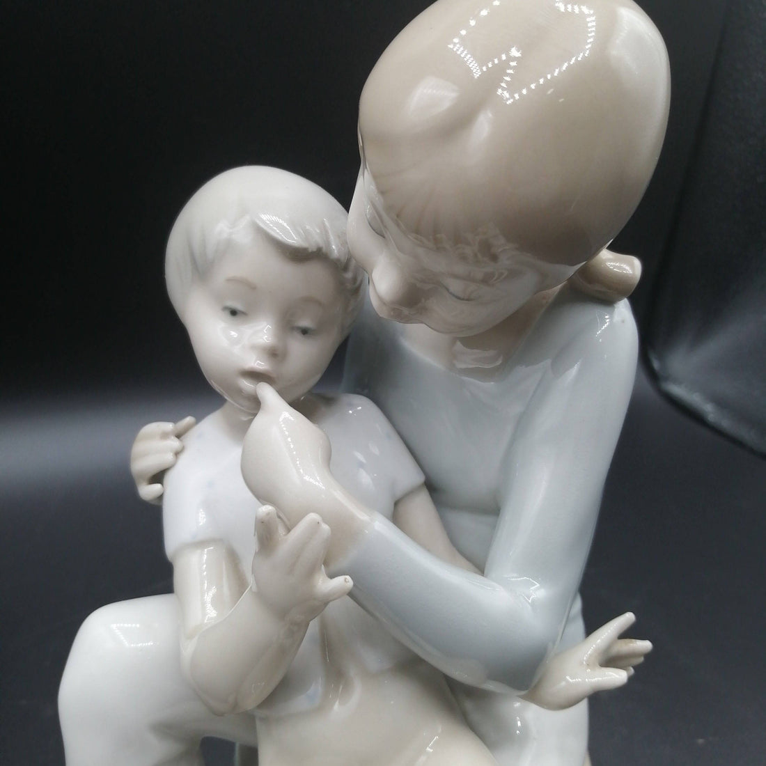Figura de porcelana niño y niña sentada | Elegancia y calidad con acabado brillante, ideal para decoración vintage en hogar o colección.
