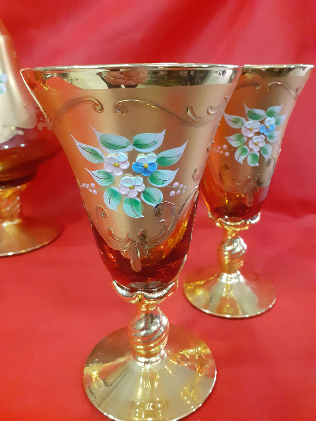 Botella de licor Murano con 6 copas exquisitas, pintadas a mano en cristal dorado con detalles florales, decoración vintage elegante.