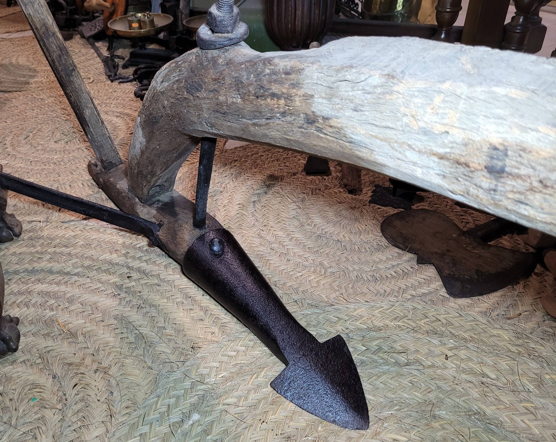 Punta metálica del Arado Romano sobre estructura de madera curvada, pieza decorativa de labranza tradicional para hogar o jardín.