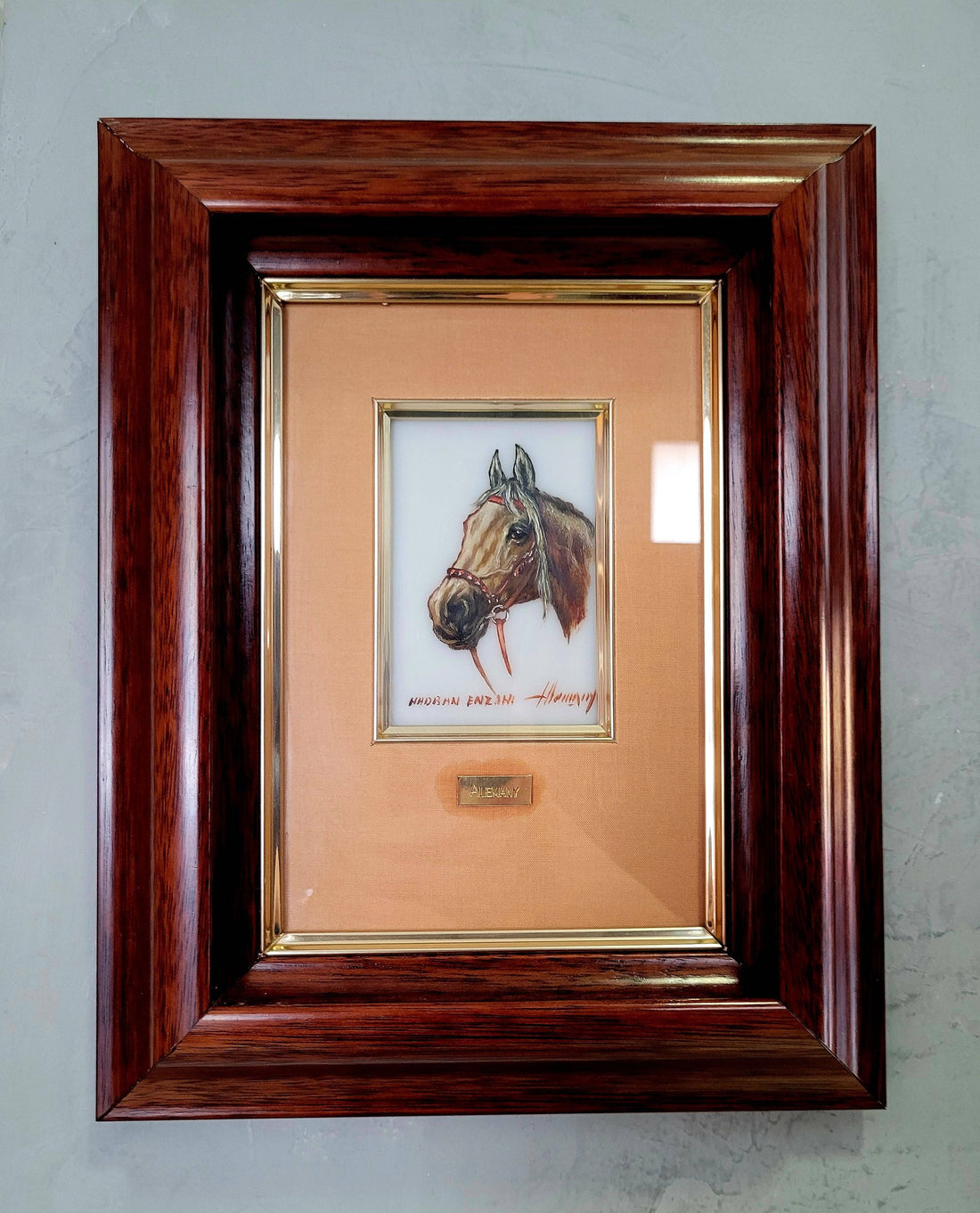 Pintura Sobre Cristal Cabeza Caballo Hadran Enzahi Alemany enmarcada con marco de madera oscura y fondo beige. Decoración elegante para el hogar.