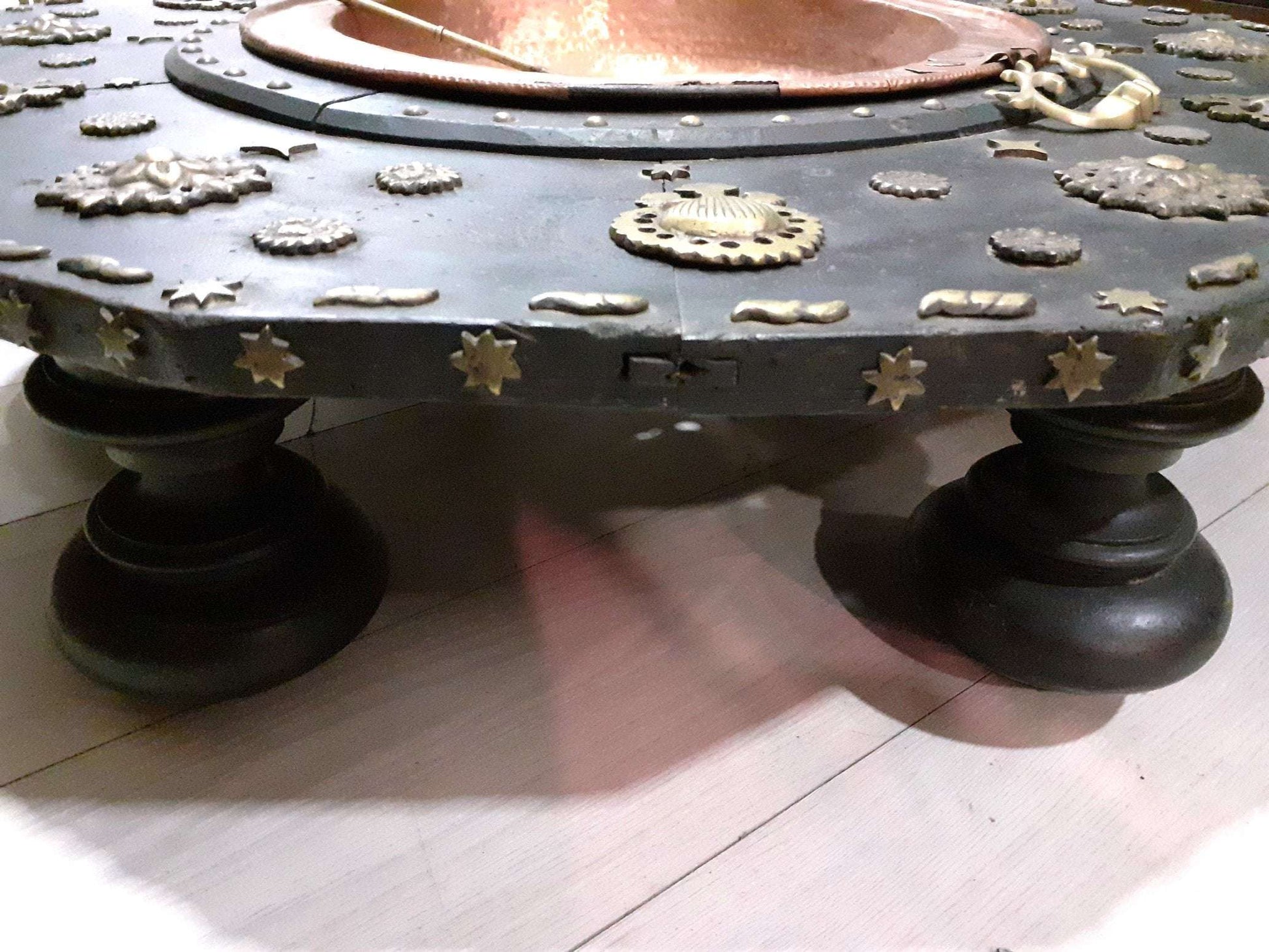 Brasero de cobre con base de madera negra decorada con estrellas y relieves metálicos, estilo vintage del siglo XVIII para decoración del hogar.