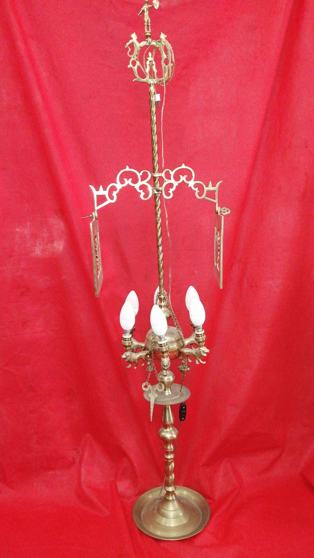 Velón antiguo electrificado de metal con diseño ornamental y bombillas, ideal para decoración vintage en interiores elegantes.